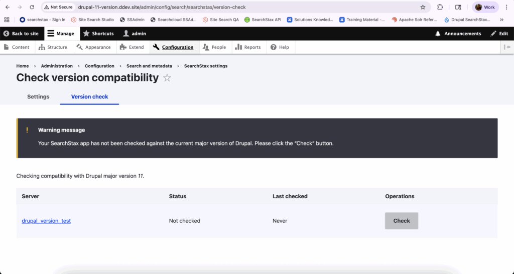 Warning notification shows SearchStax app needs version compatibility check with Drupal 11, with an unchecked status in the version test table.